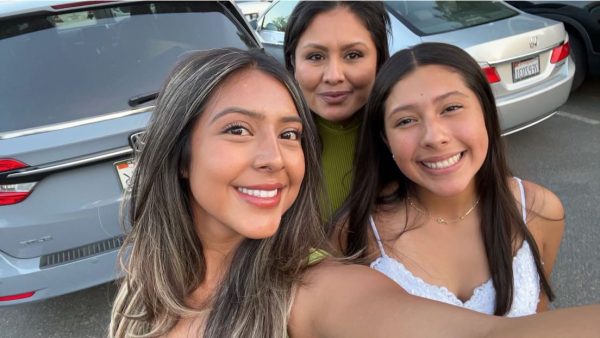 Ms. Zamora stands with her daughters on a day out.  