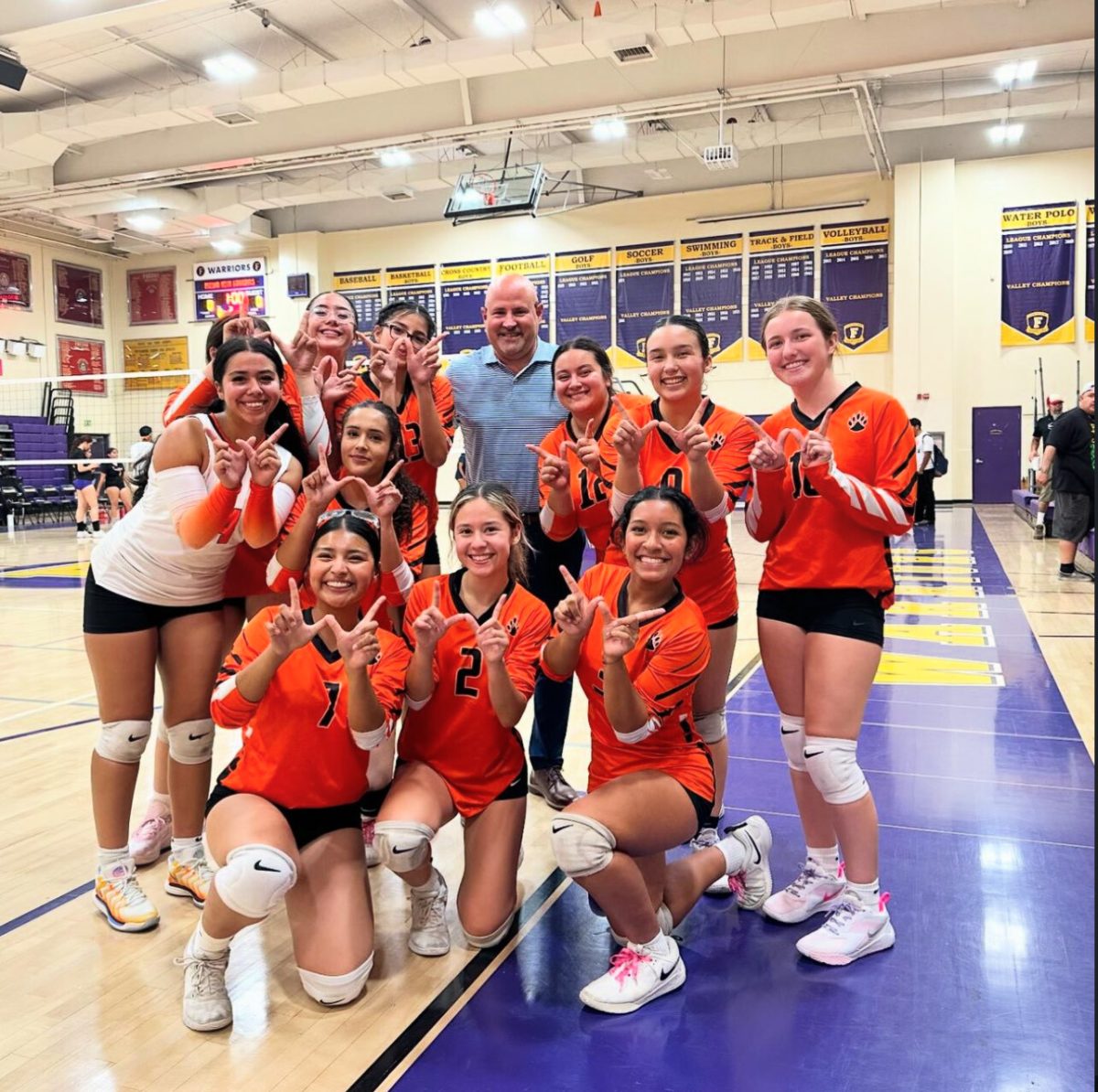 The volleyball team, being supported by Principal Lane at a match.