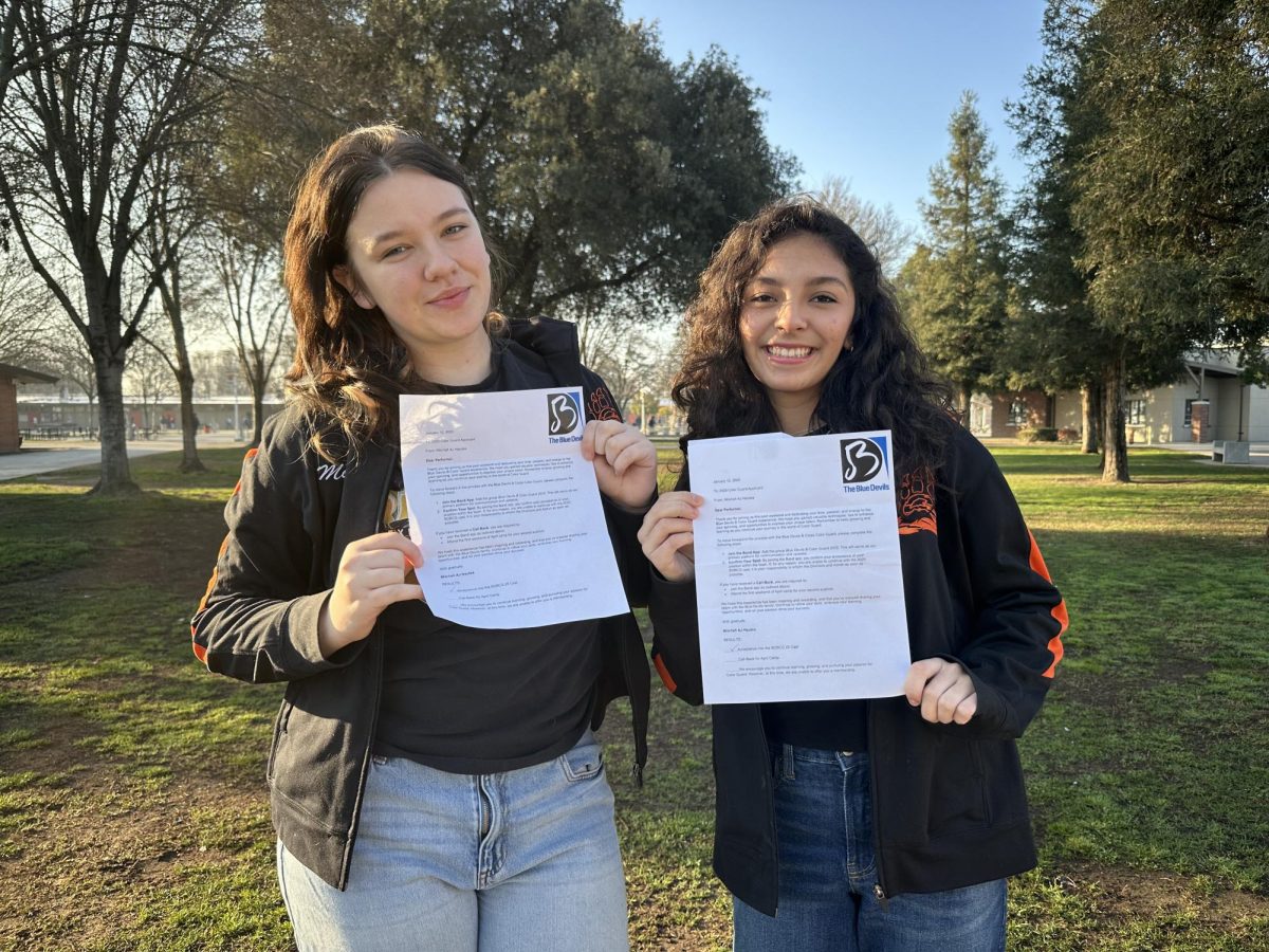 Madison Akin and Bethany Cazares posing with their acceptance letters