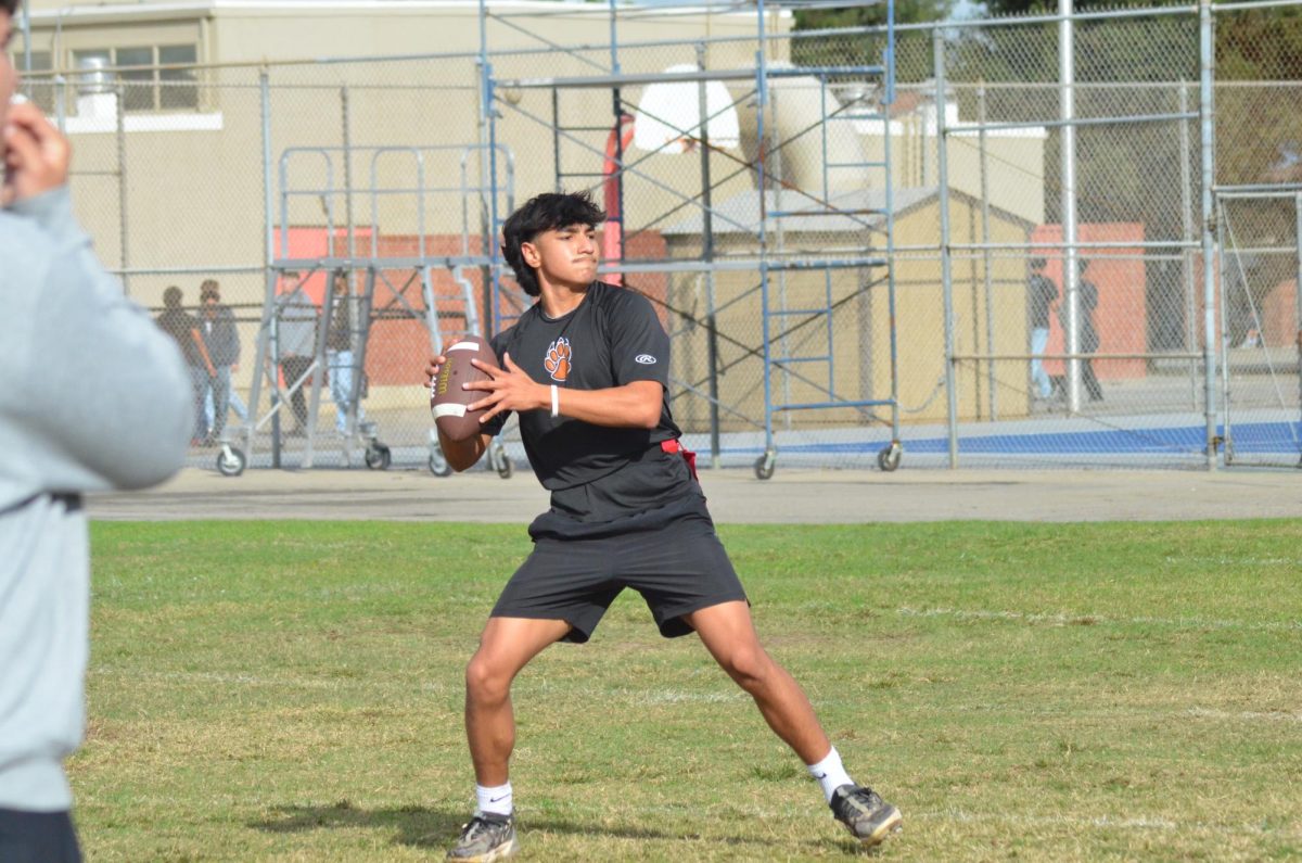 Jiovanni Tovar prepares to pass a football to his teammate.
